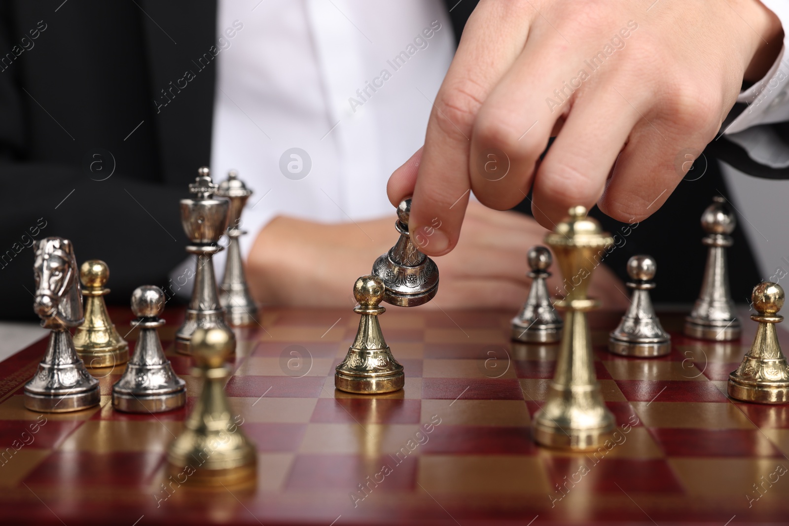 Photo of Businessman playing chess on chessboard, closeup. Competition concept