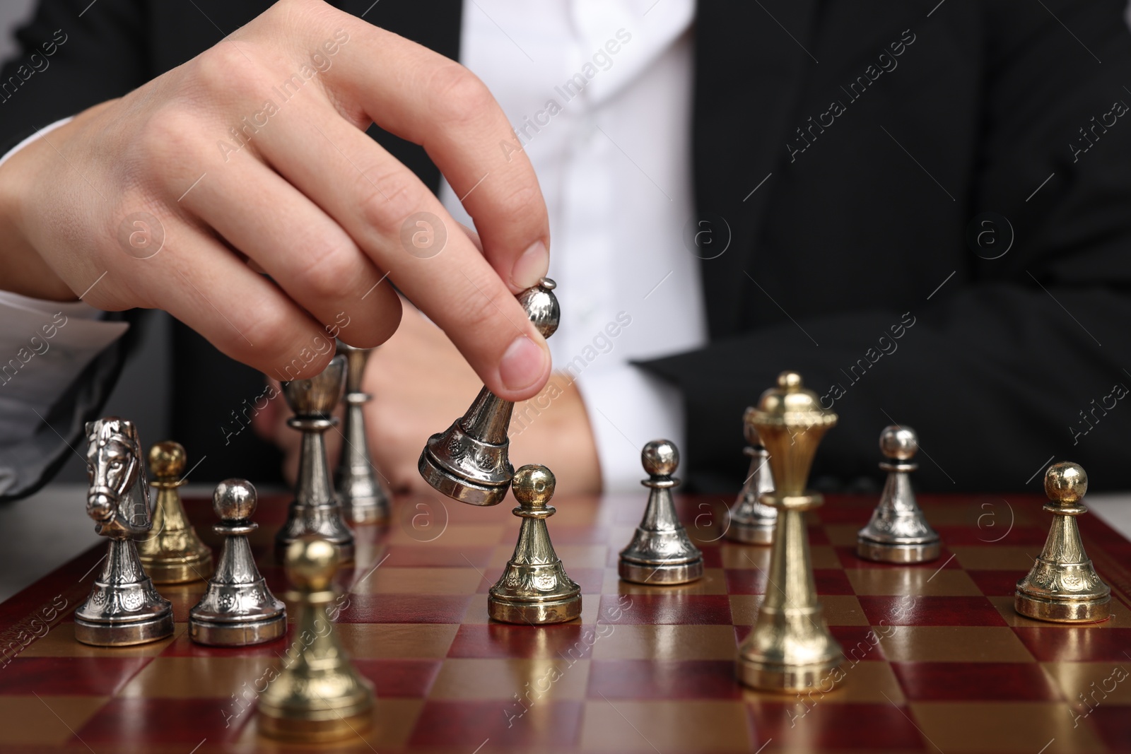 Photo of Businessman playing chess on chessboard, closeup. Competition concept