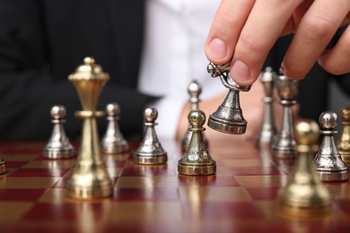 Photo of Businessman playing chess on chessboard, closeup. Competition concept