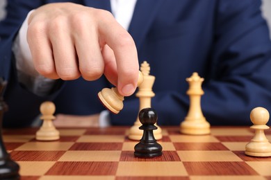 Photo of Businessman playing chess on chessboard, closeup. Competition concept