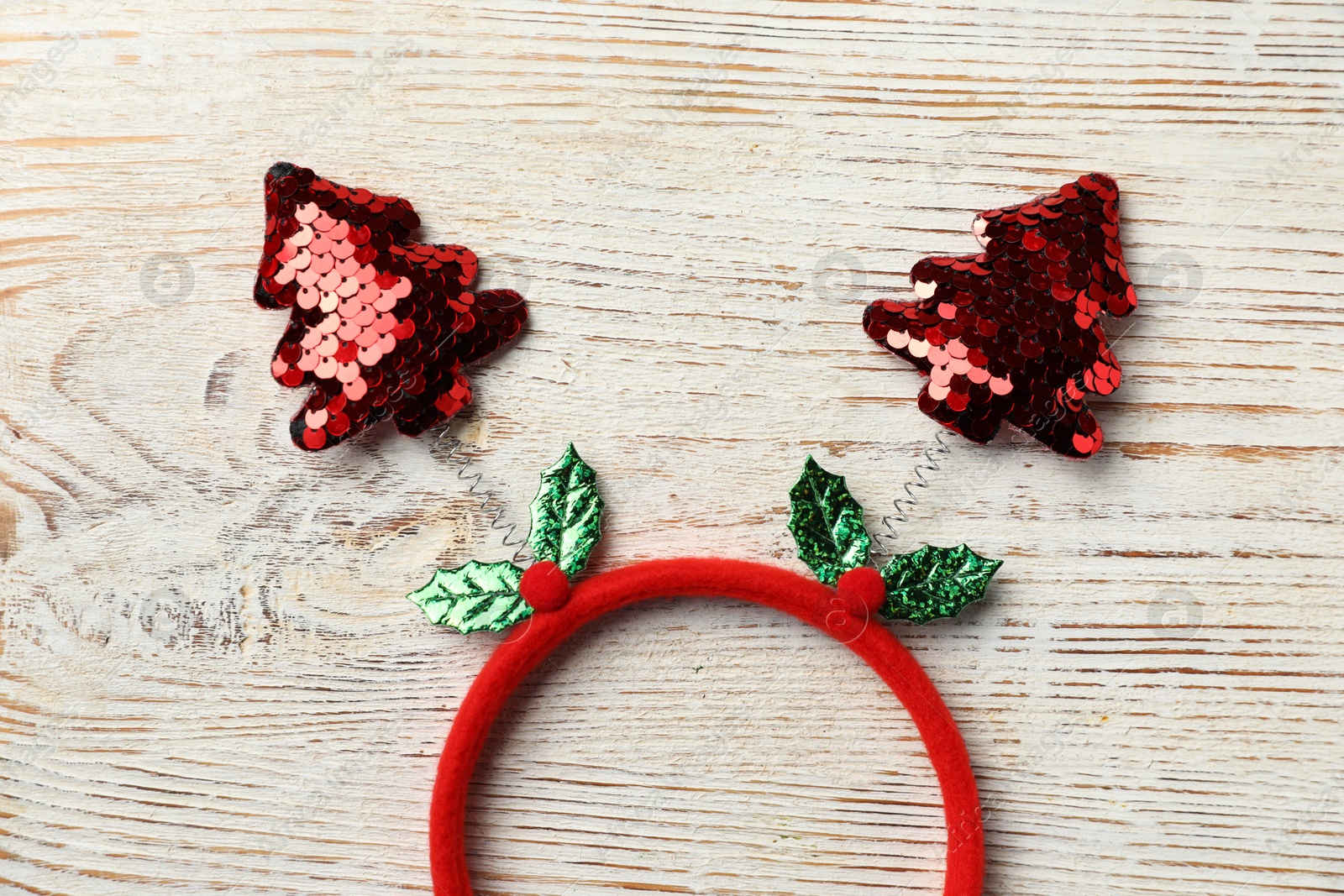 Photo of Stylish party headband on white wooden background, top view. Christmas accessory