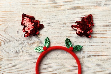 Photo of Stylish party headband on white wooden background, top view. Christmas accessory