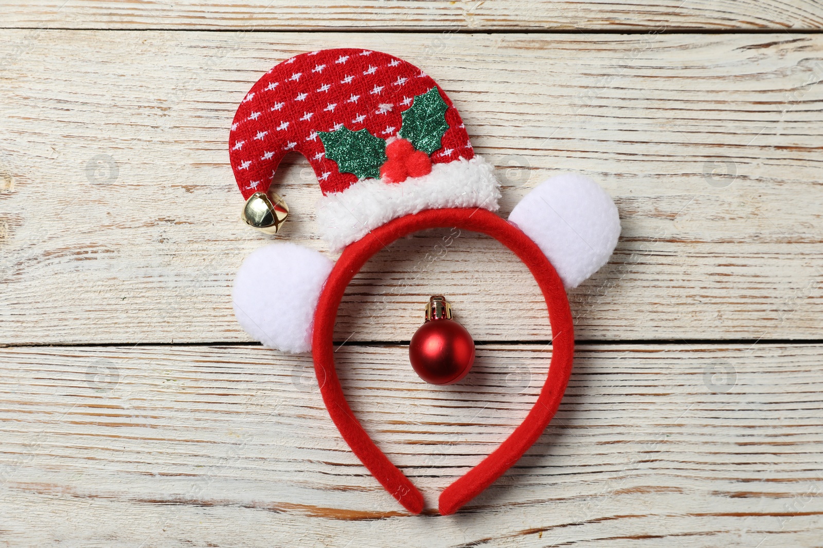 Photo of Stylish party headband and Christmas bauble on white wooden background, top view