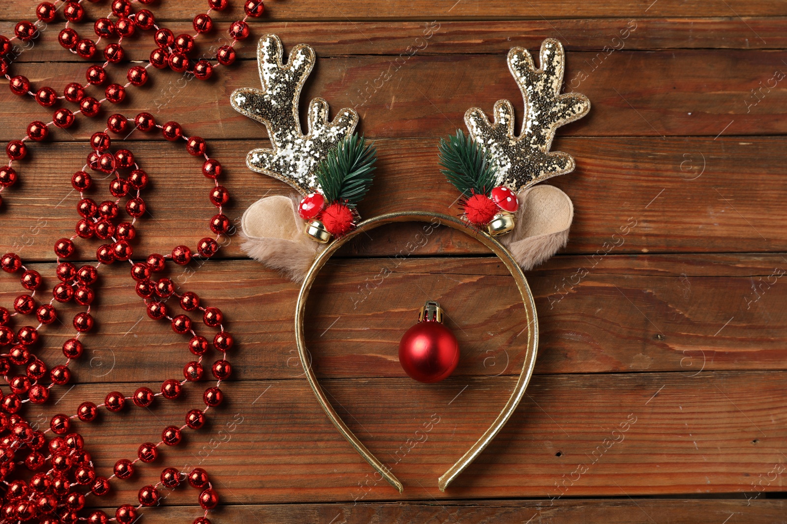 Photo of Beautiful reindeer headband and Christmas decor on wooden background, flat lay