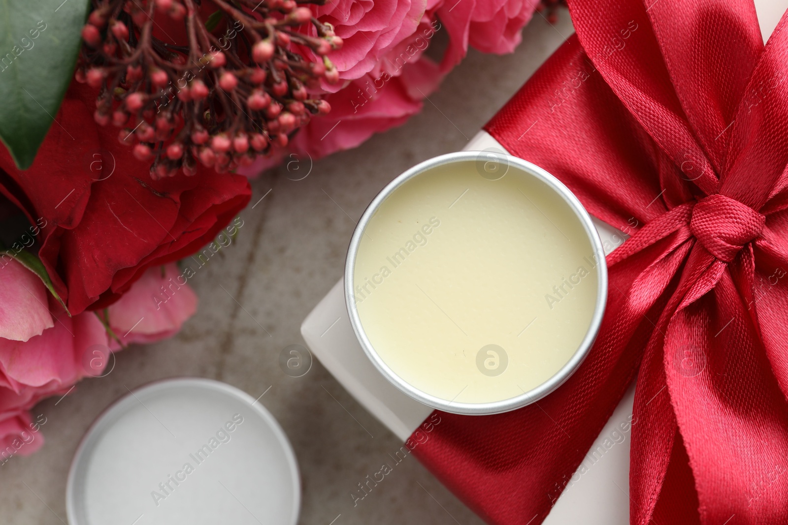 Photo of Natural solid perfume, gift box and flowers on light table, flat lay