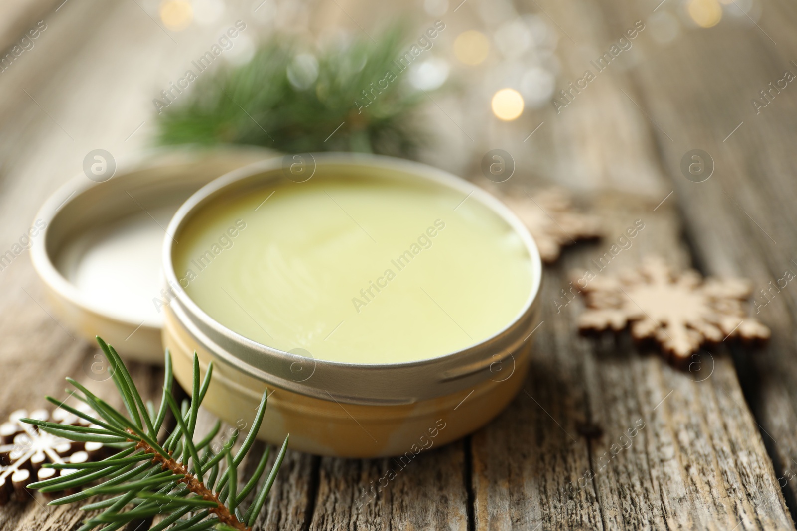 Photo of Natural solid perfume in container and Christmas decor on wooden table, closeup