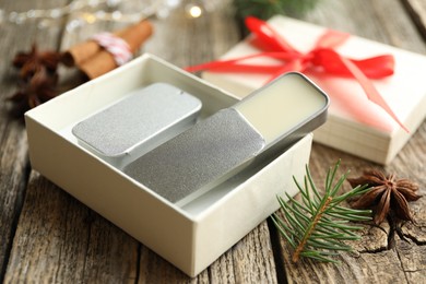 Photo of Natural solid perfume in gift box, spices and fir on wooden table, closeup