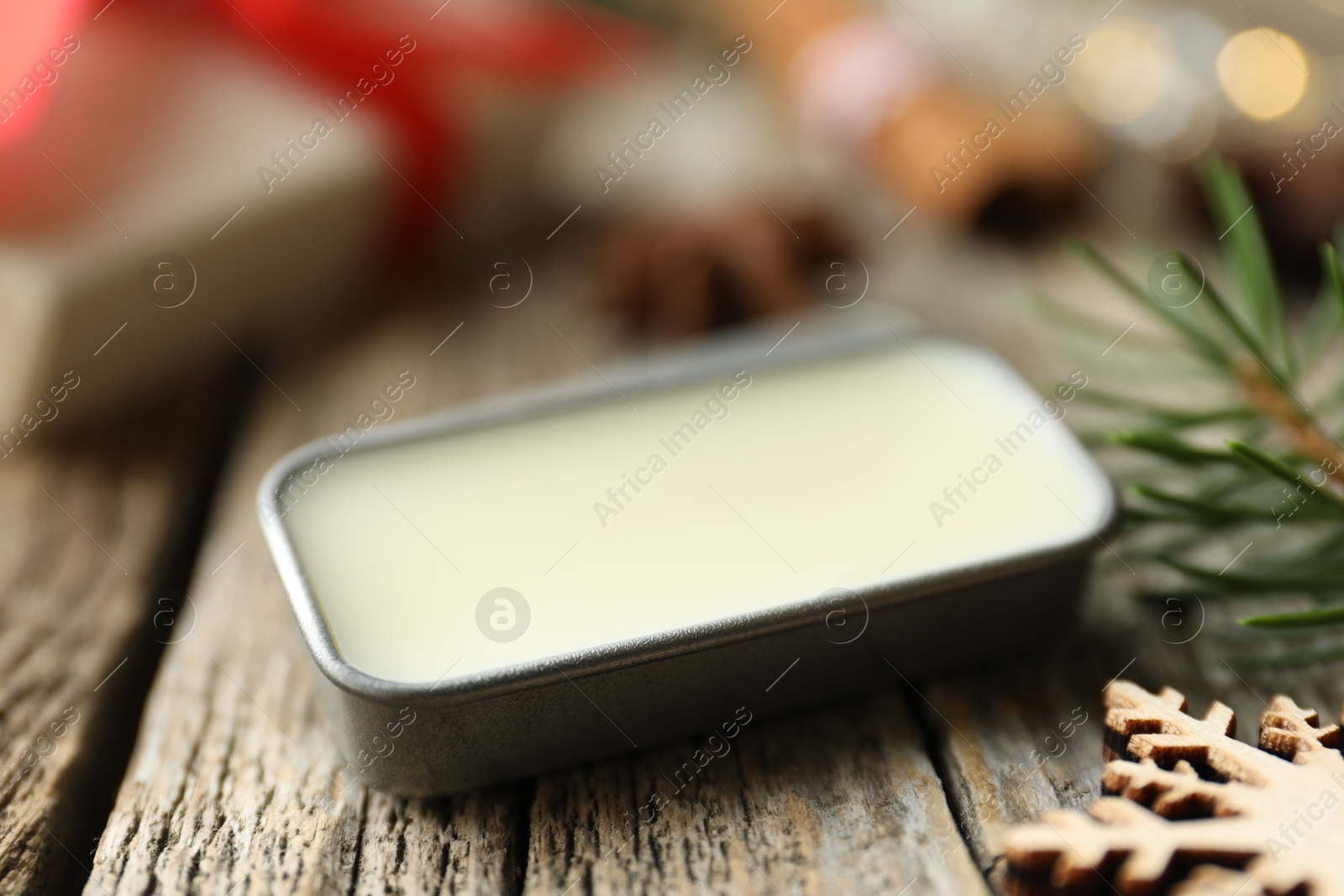 Photo of Natural solid perfume in container and Christmas decor on wooden table, closeup