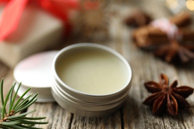 Photo of Natural solid perfume in container and anise star on wooden table, closeup