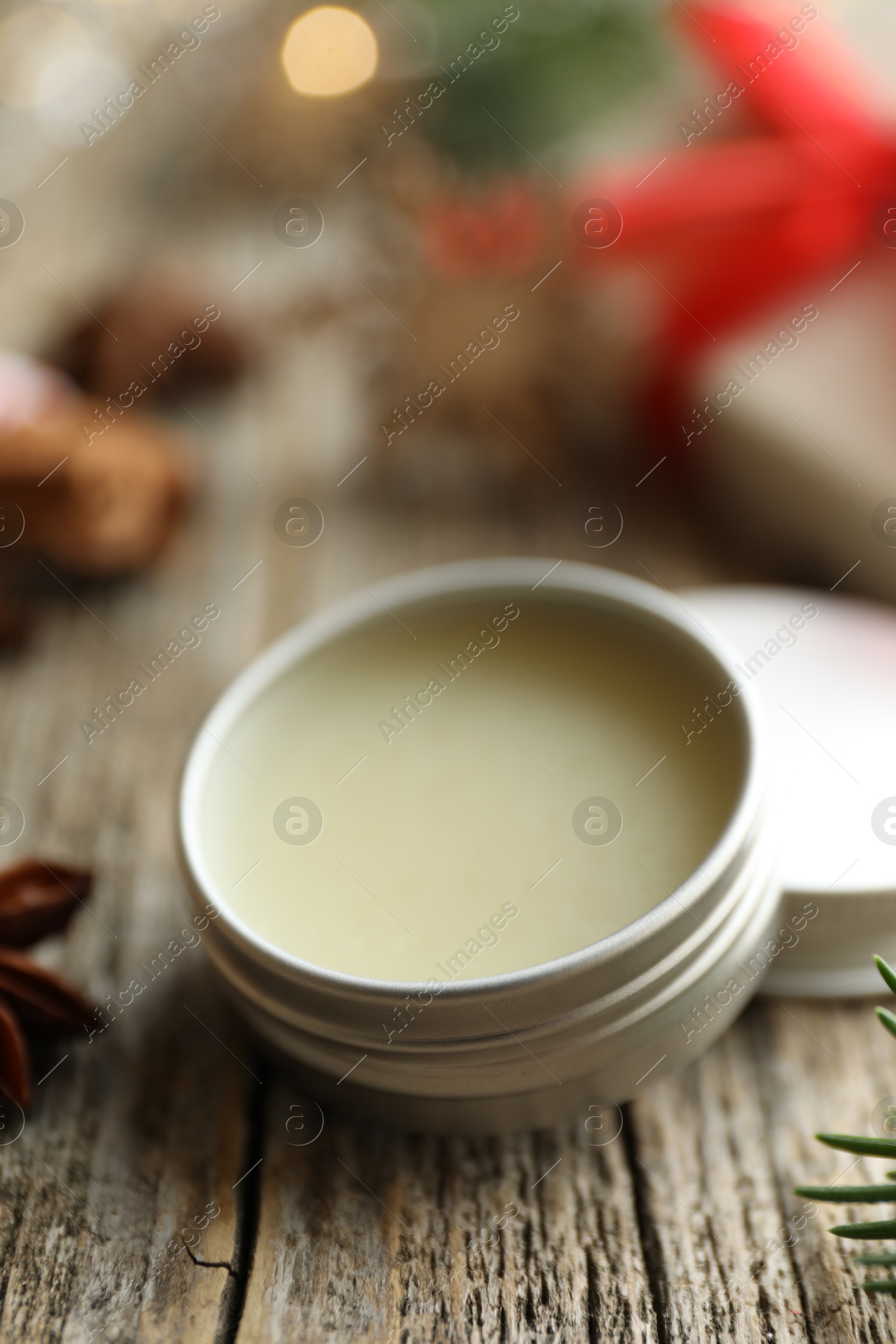 Photo of Natural solid perfume in container on wooden table, closeup