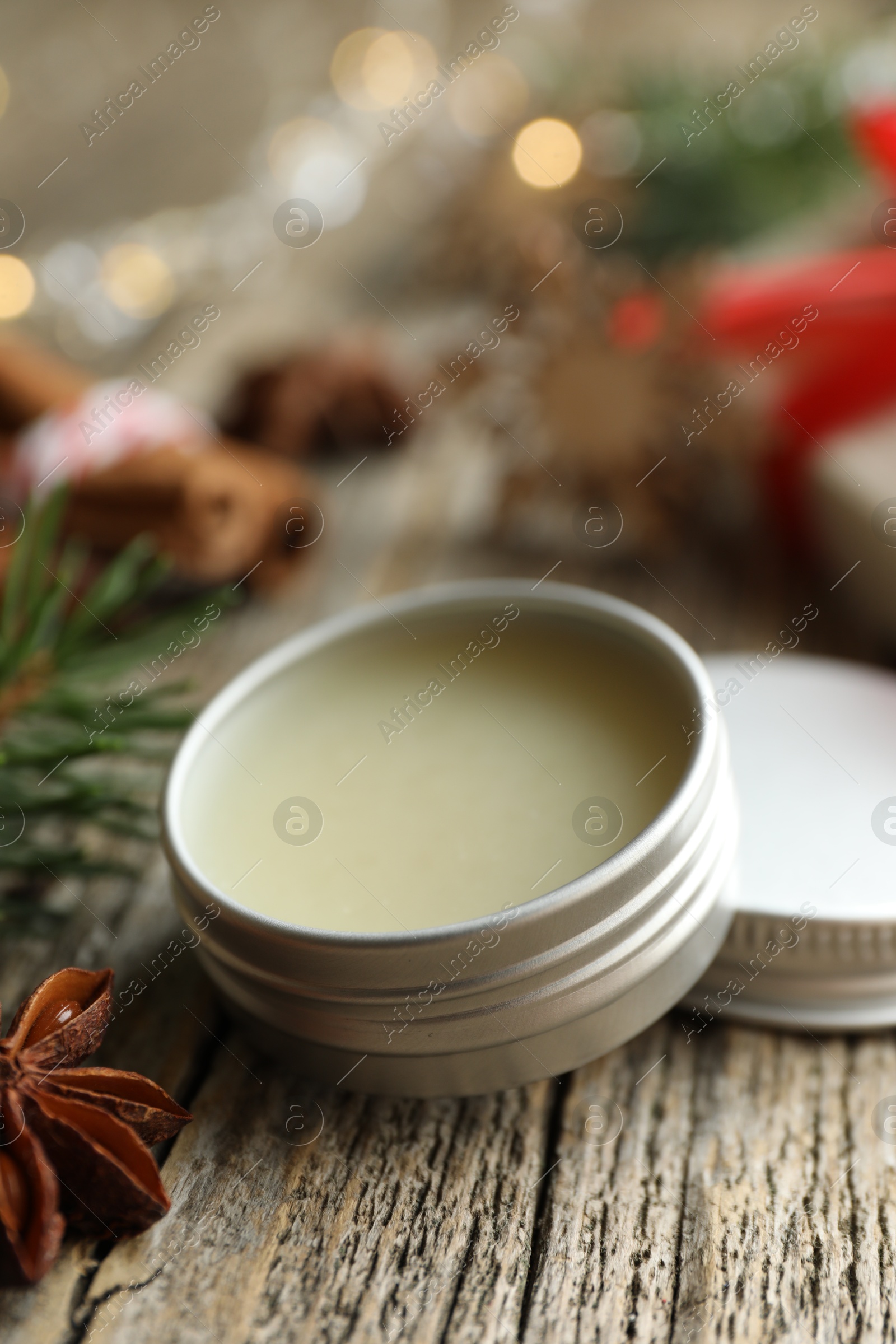 Photo of Natural solid perfume in container and anise star on wooden table, closeup