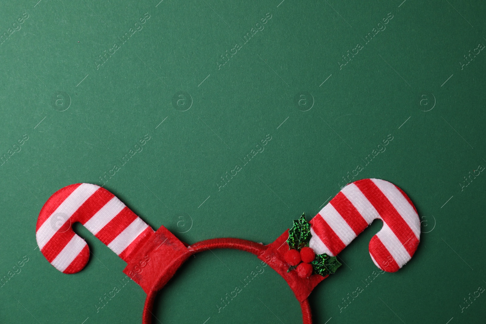 Photo of Stylish party headband on green background, top view with space for text. Christmas accessory