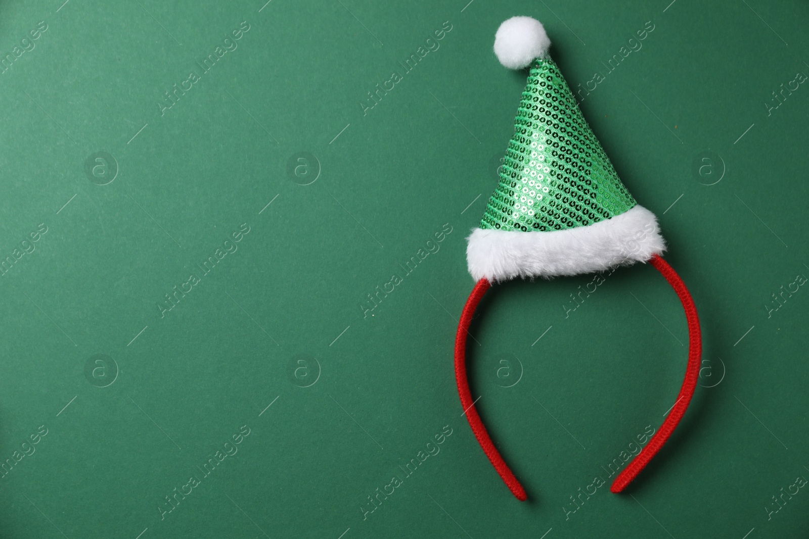 Photo of Stylish party headband on green background, top view with space for text. Christmas accessory