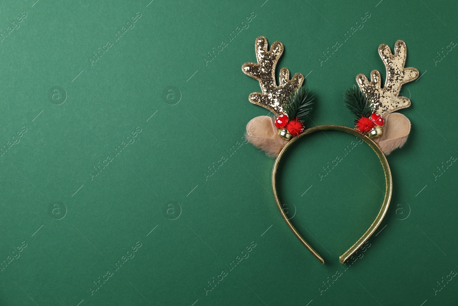 Photo of Beautiful reindeer headband on green background, top view with space for text. Christmas accessory