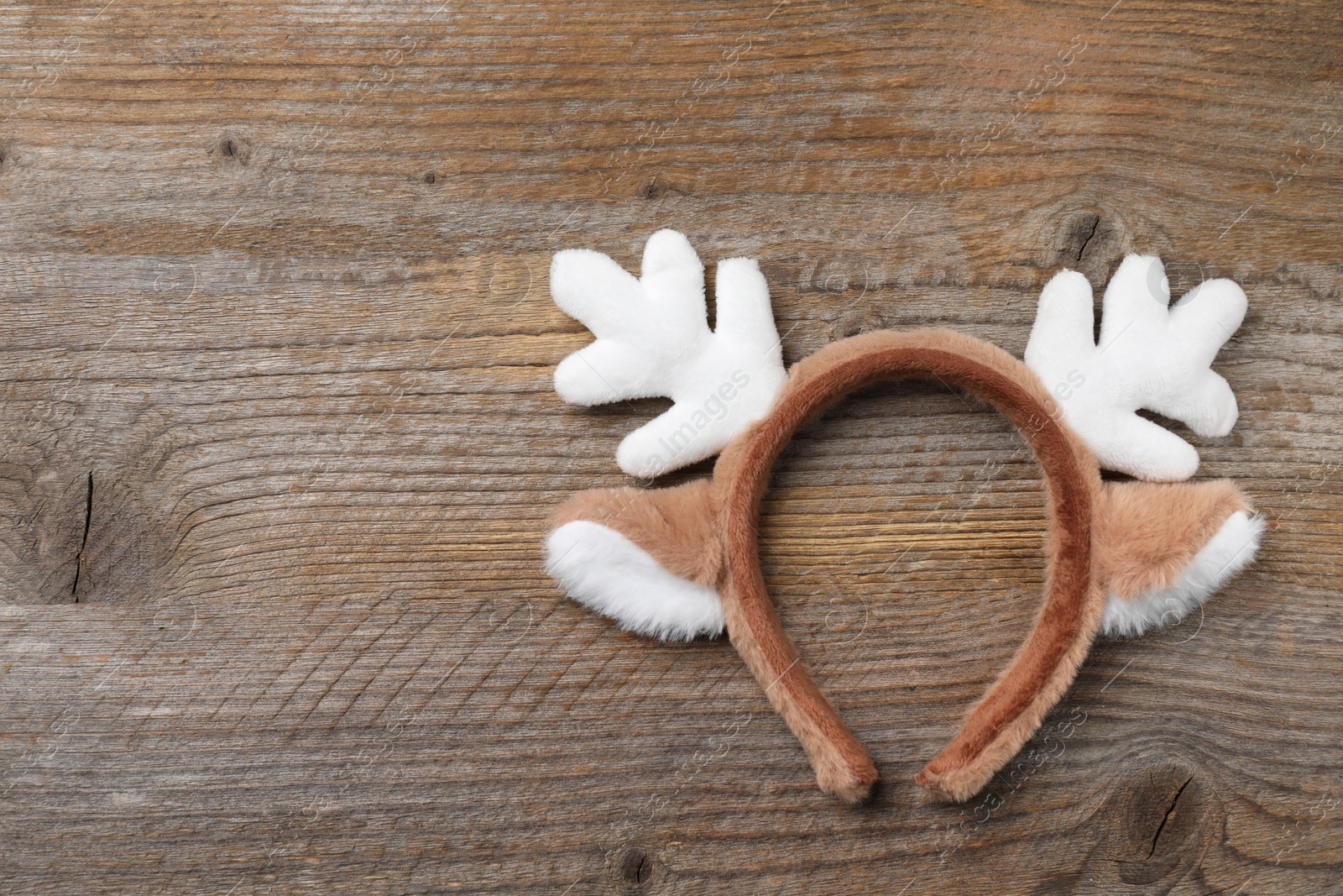 Photo of Beautiful reindeer headband on wooden background, top view with space for text. Christmas accessory