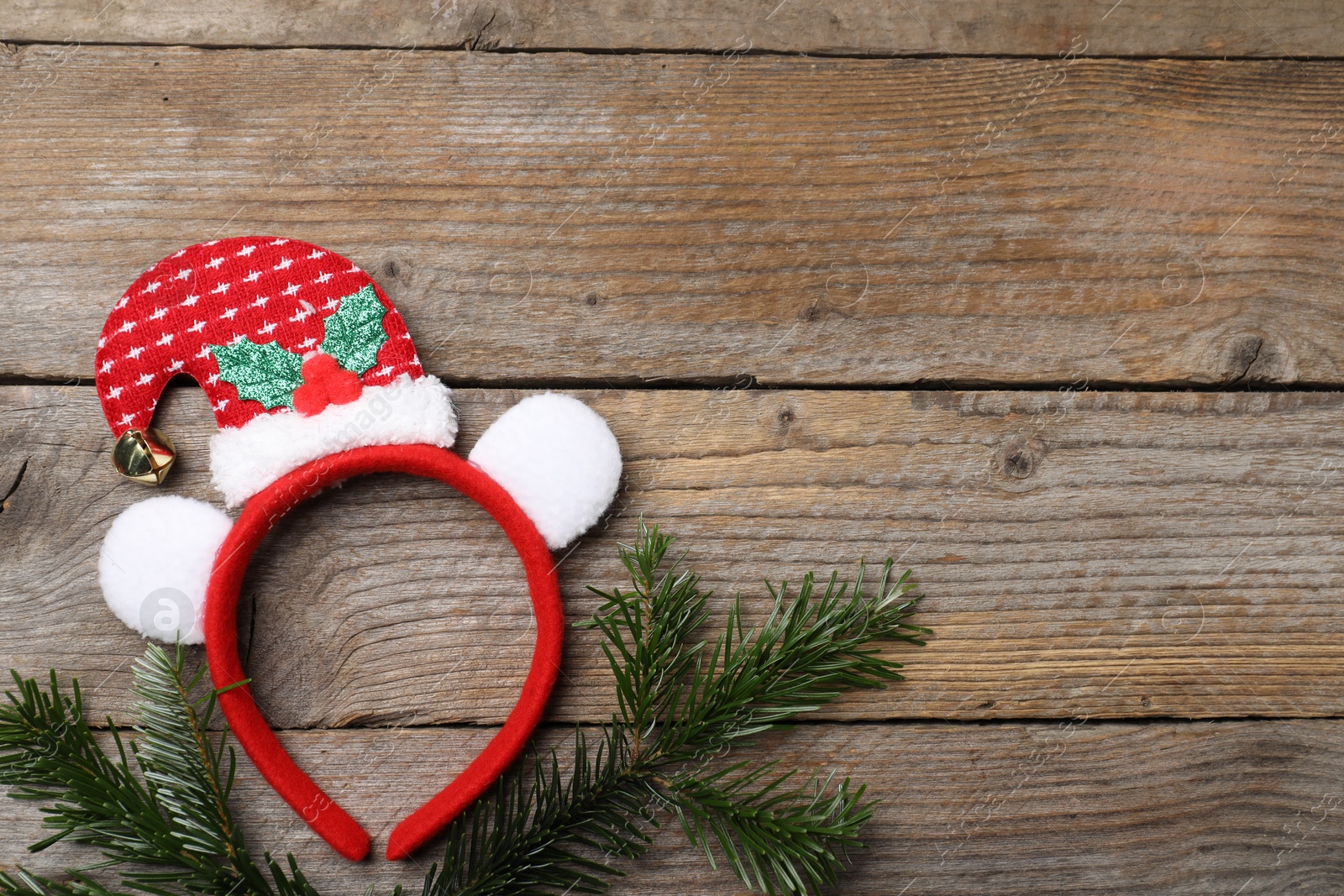 Photo of Stylish party headband and fir branches on wooden background, top view with space for text. Christmas accessory