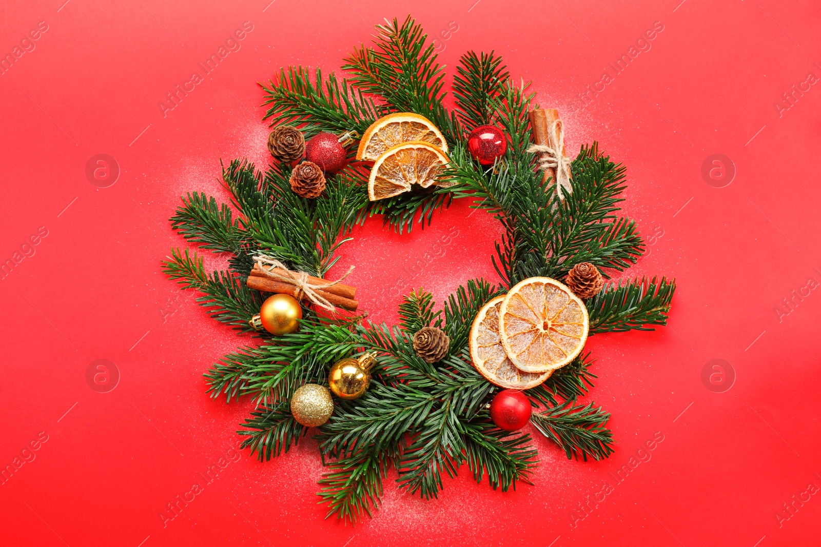 Photo of Different spices, dried orange slices and fir tree branches on red background, flat lay. Christmas season