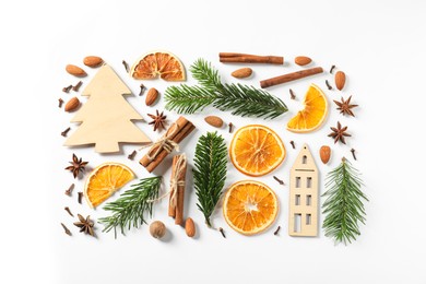 Photo of Different spices, dried orange slices and fir tree branches on white table, flat lay. Christmas season