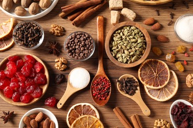 Photo of Different aromatic spices on wooden table, flat lay. Christmas season