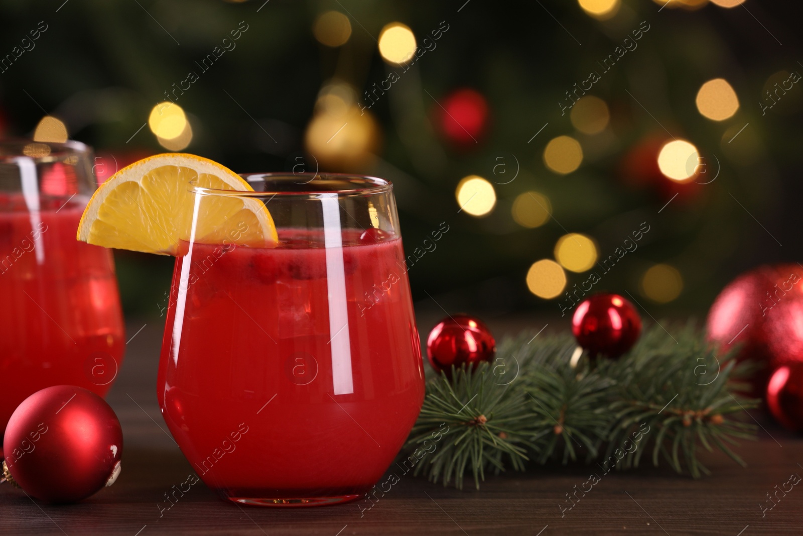 Photo of Christmas cocktail in glasses with lemon and decor on wooden table, closeup