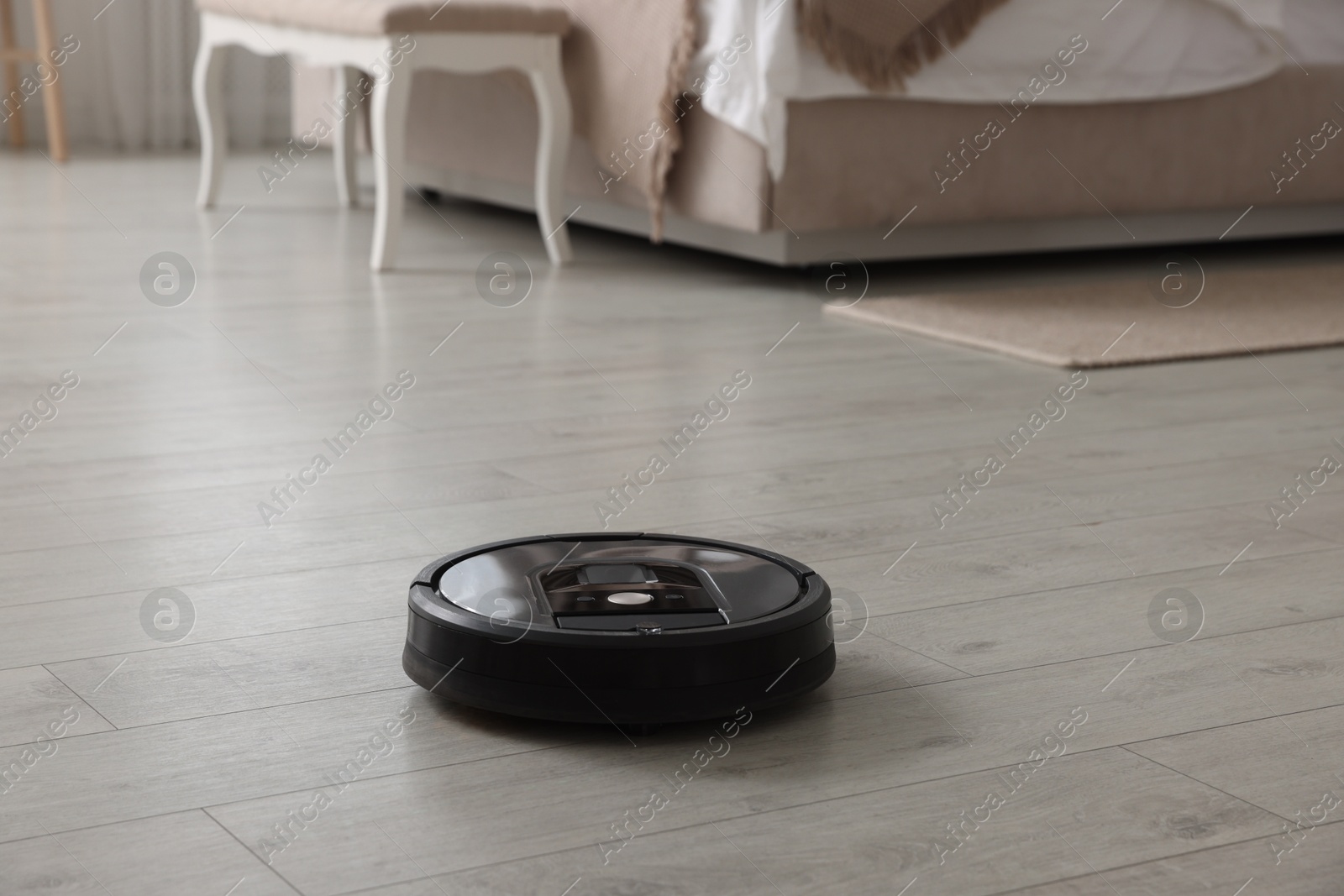 Photo of Robotic vacuum cleaner on wooden floor indoors