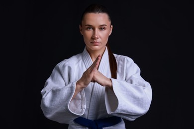 Photo of Karate fighter in kimono on black background