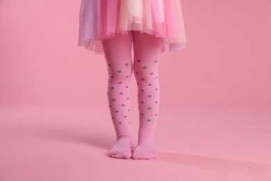 Photo of Child wearing tights on pink background, closeup