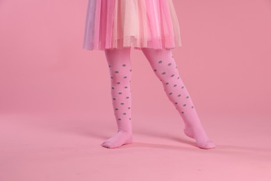 Photo of Child wearing tights on pink background, closeup