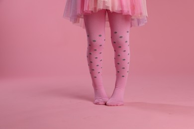 Photo of Child wearing tights on pink background, closeup