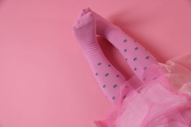 Photo of Child wearing tights on pink background, top view. Space for text