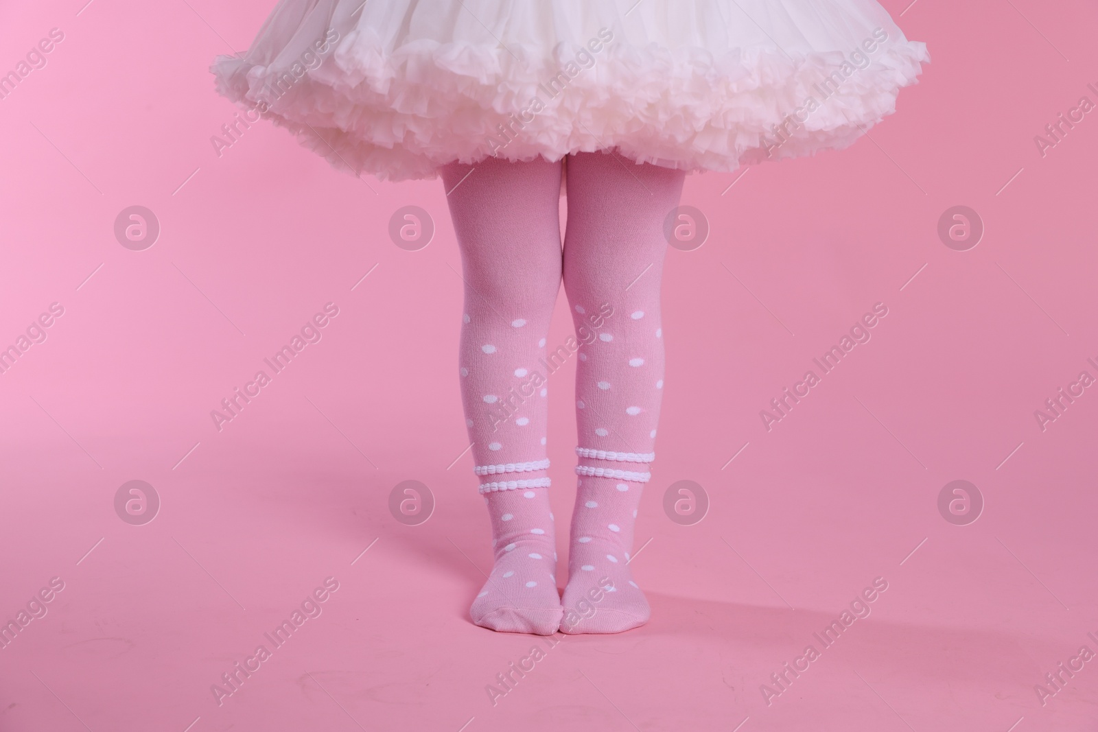 Photo of Child wearing tights on pink background, closeup