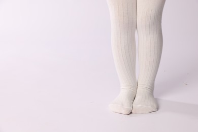 Photo of Child wearing tights on white background, closeup. Space for text