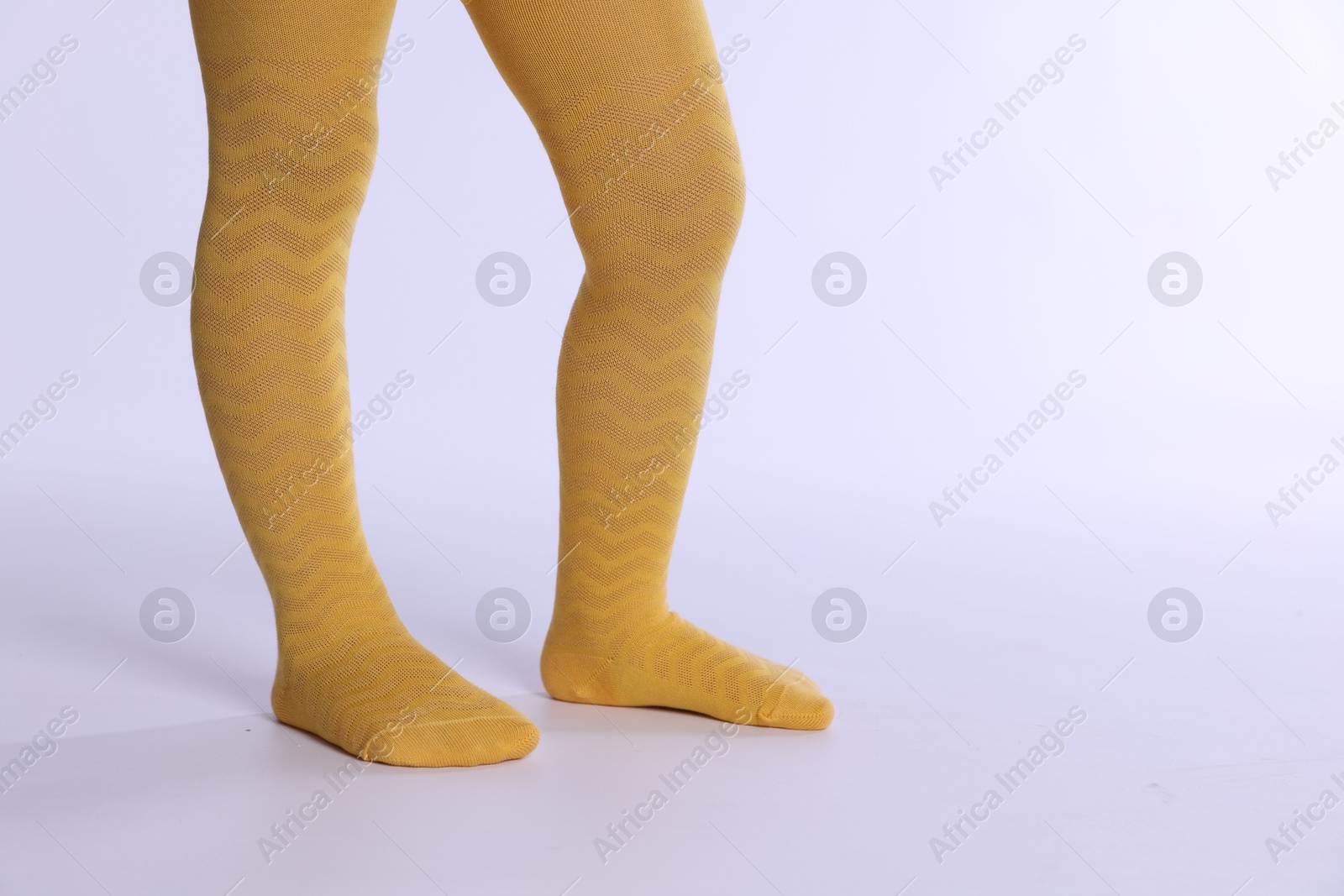 Photo of Child wearing bright tights on white background, closeup. Space for text