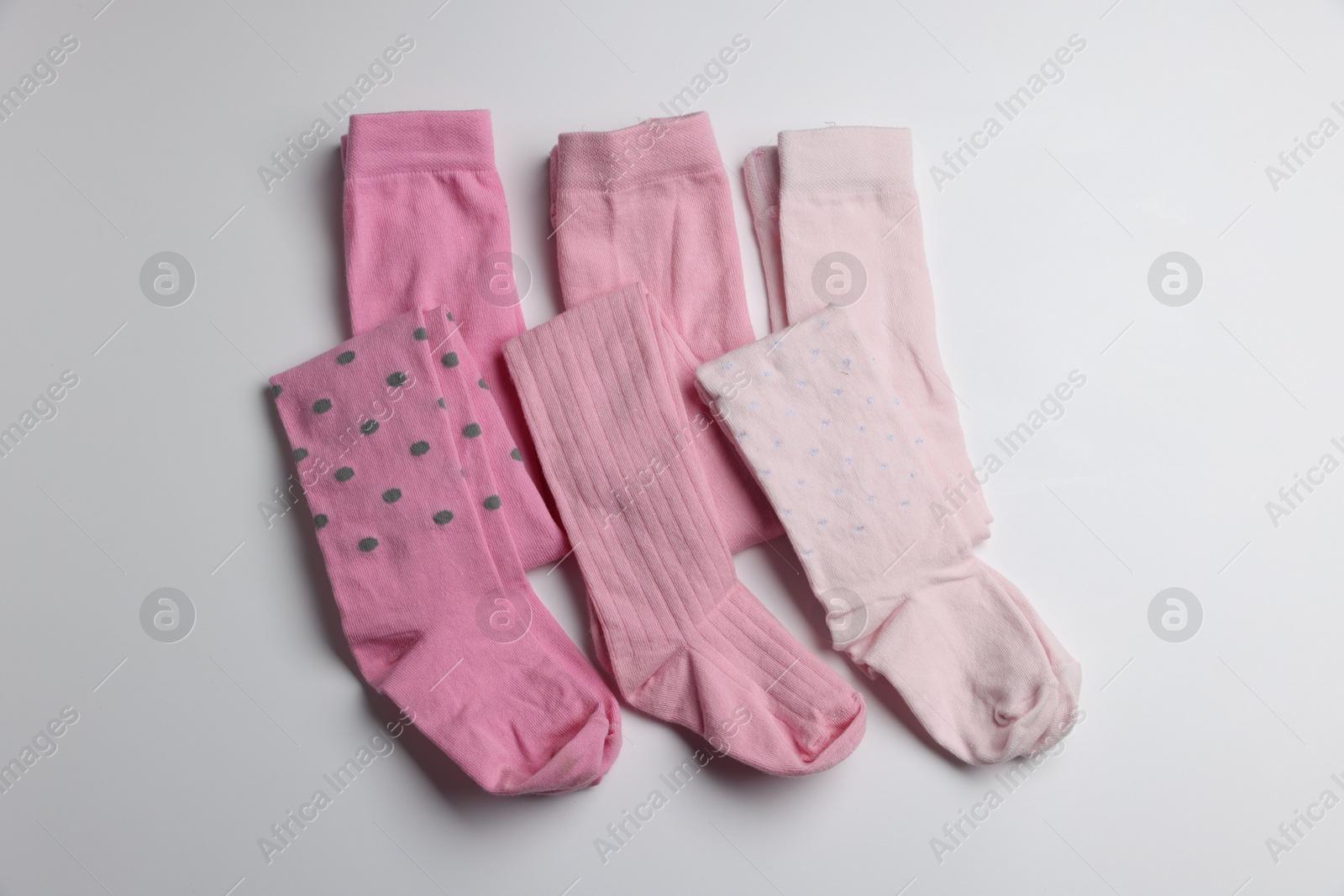 Photo of Beautiful pink child's tights on white background, top view