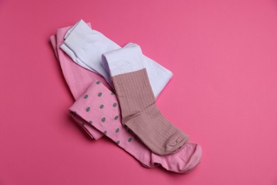 Photo of Different child's tights on pink background, above view. Space for text