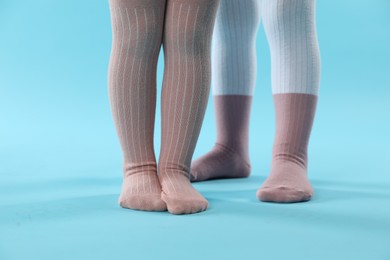 Photo of Kids wearing tights on light blue background, closeup