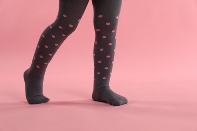 Photo of Child wearing tights on pink background, closeup. Space for text