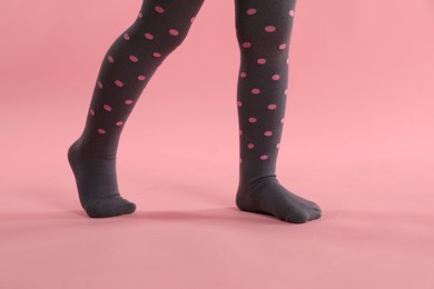 Photo of Child wearing tights on pink background, closeup