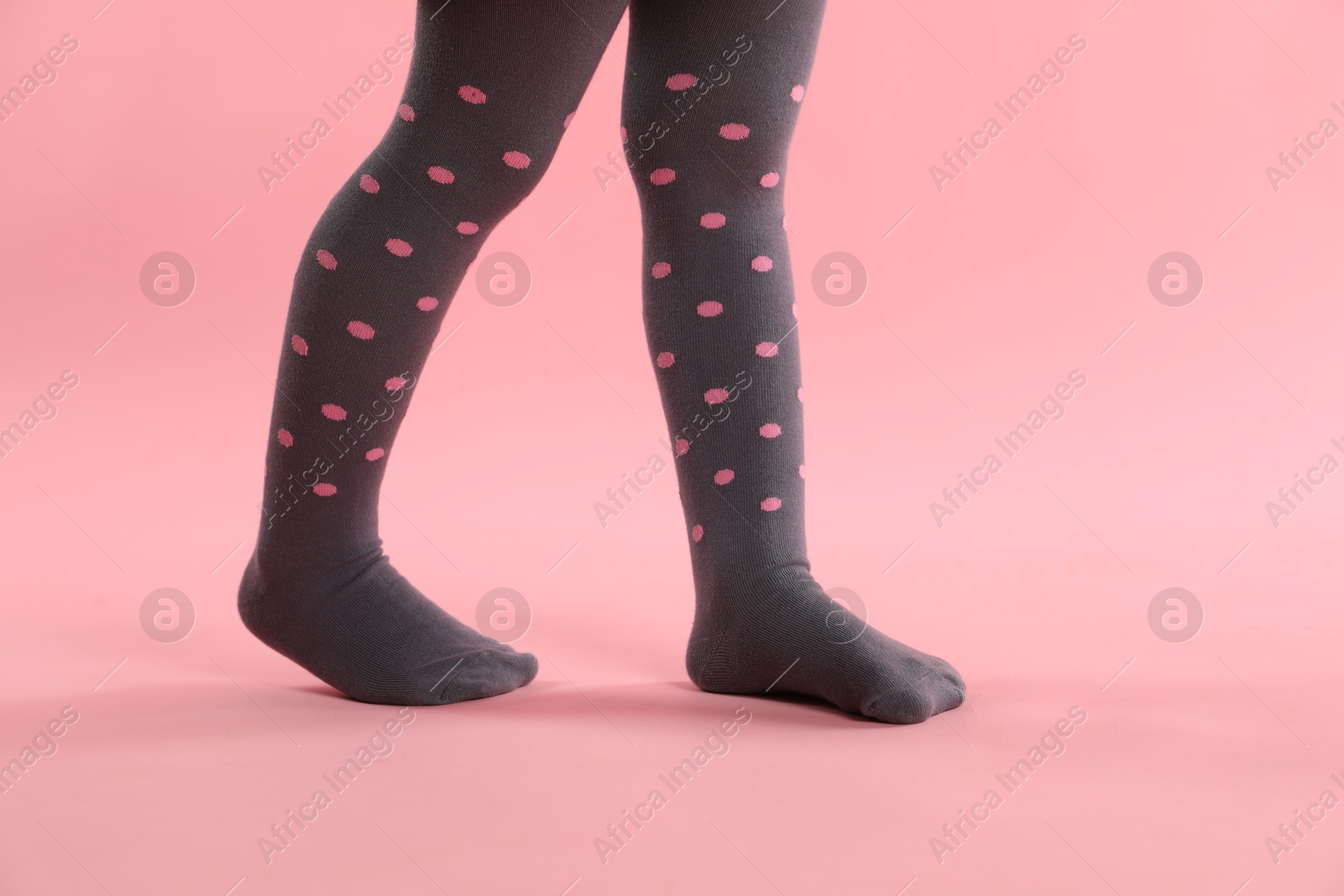 Photo of Child wearing tights on pink background, closeup