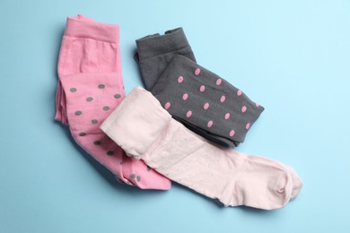 Photo of Different child's tights on light blue background, flat lay