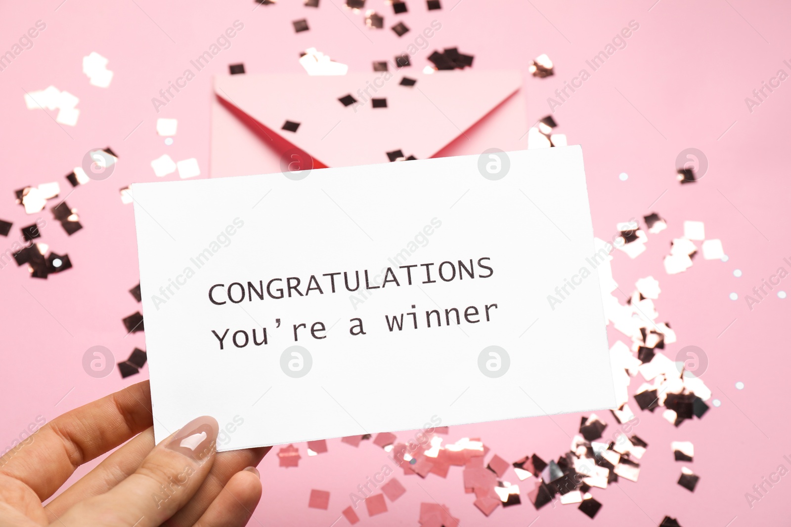 Photo of Woman holding card with phrase Congratulations You`re Winner on pink background, closeup