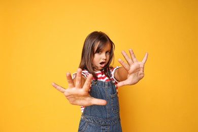 Photo of Portrait of scared little girl on orange background