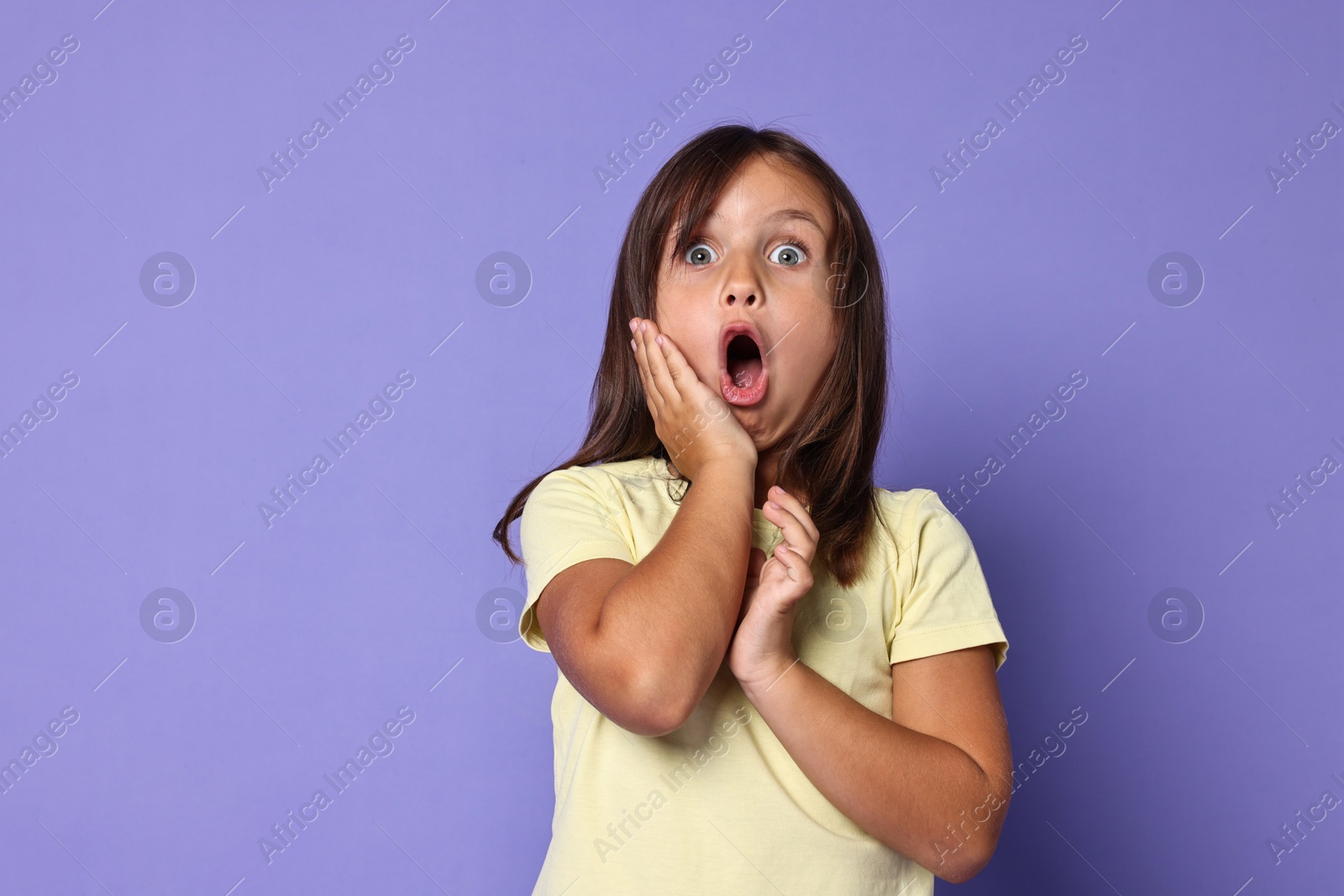 Photo of Portrait of scared little girl on violet background. Space for text