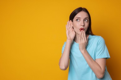 Photo of Woman showing hand to ear gesture on orange background, space for text