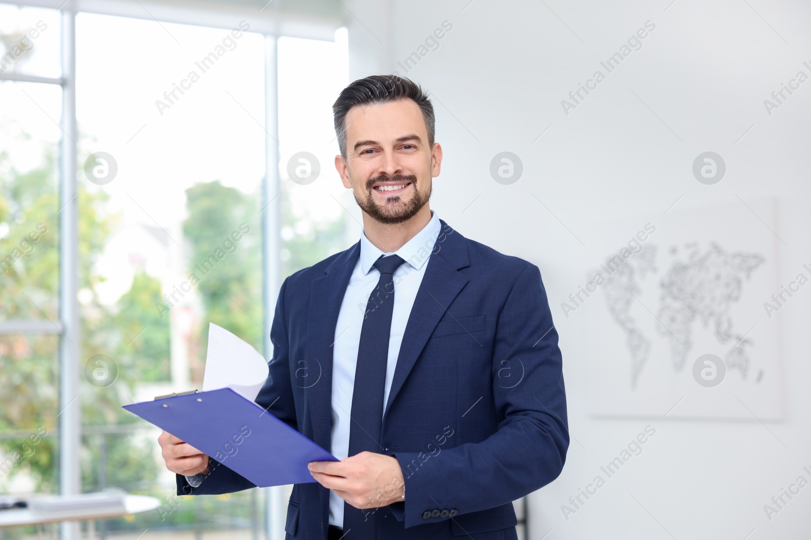 Photo of Portrait of smiling banker with clipboard in office