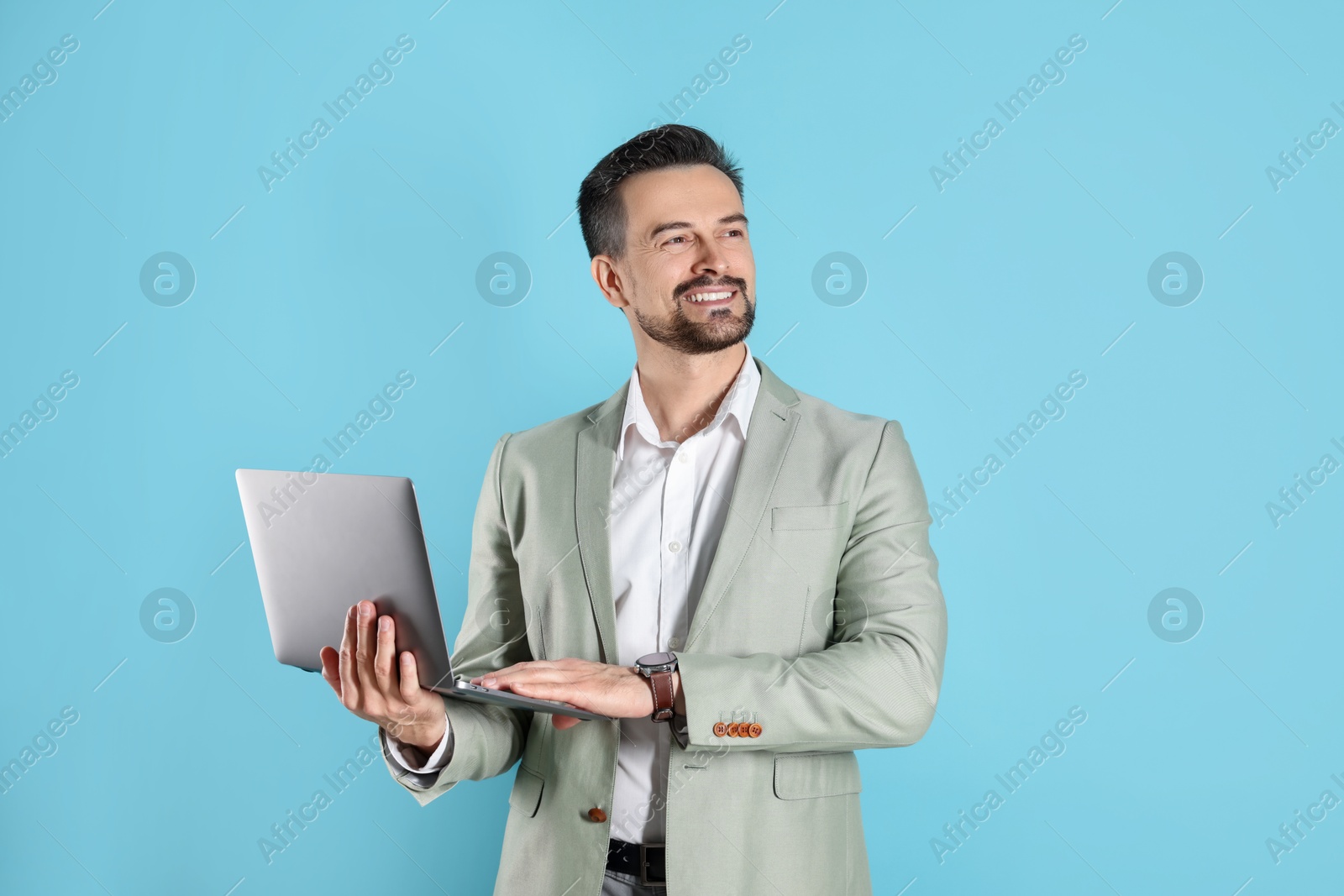 Photo of Smiling banker with laptop on light blue background