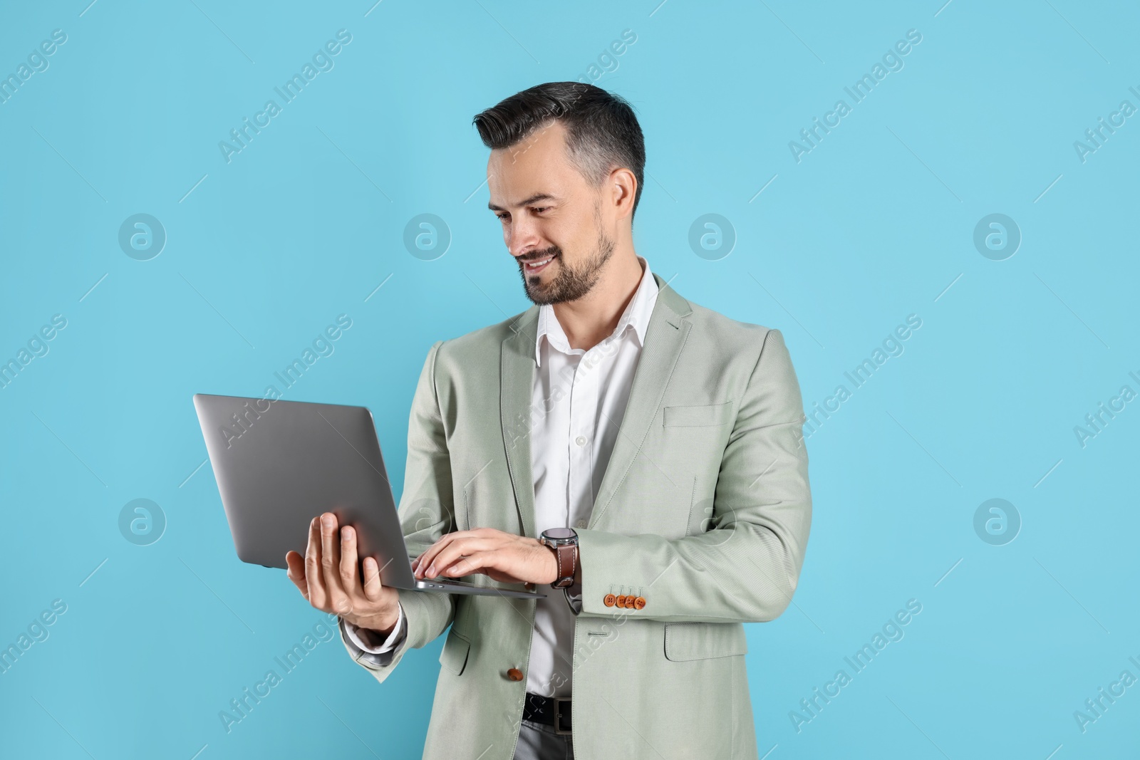 Photo of Smiling banker with laptop on light blue background