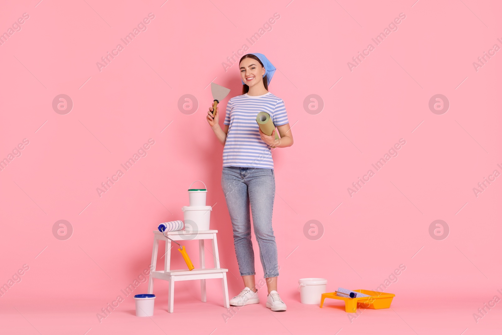 Photo of Young decorator with different tools on pink background