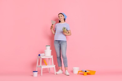 Photo of Young decorator with different tools on pink background