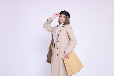 Photo of Happy postwoman with bag and envelopes on white background